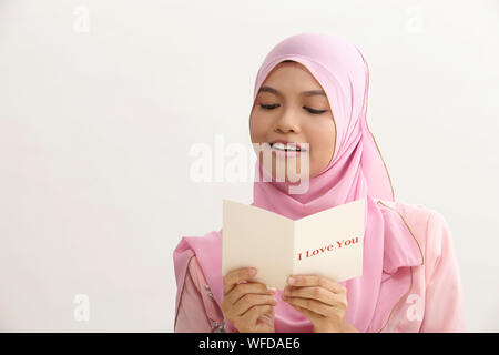 Donna malay con tudung holding ti amo biglietto di auguri Foto Stock