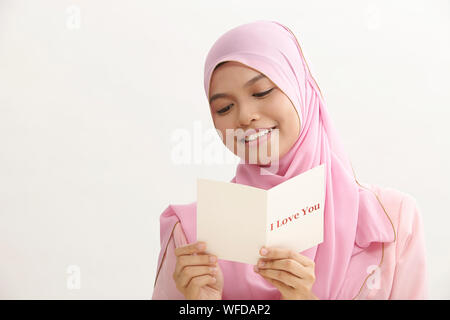 Donna malay con tudung holding ti amo biglietto di auguri Foto Stock