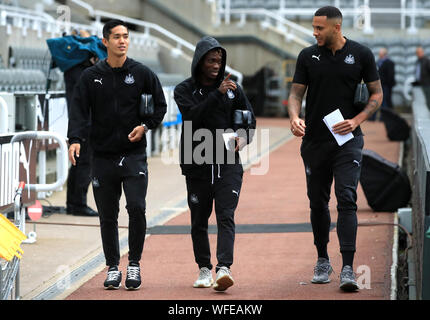 Newcastle United's Yoshinori Muto (sinistra) e Christian Atsu e Jamaal Lascelles (destra) arrivano a terra davanti alla Premier League match presso il St James Park, Londra. Foto Stock