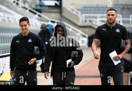 Newcastle United's Yoshinori Muto (sinistra) e Christian Atsu e Jamaal Lascelles (destra) arrivano a terra davanti alla Premier League match presso il St James Park, Londra. Foto Stock