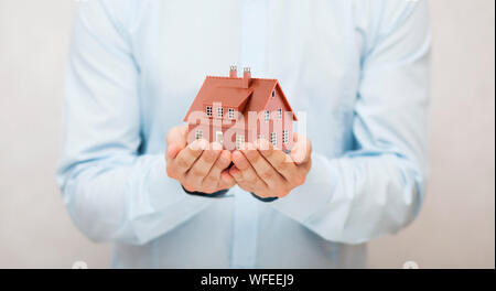 Piccolo marrone casa giocattolo in mani Foto Stock