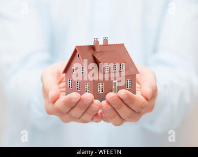 Piccolo marrone casa giocattolo in mani Foto Stock