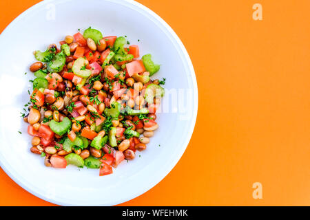 Fresco e salutare misto vegetariano Bean Insalata estiva con sedano, pomodori e prezzemolo Foto Stock