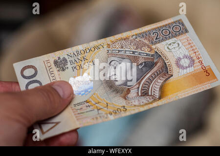 Man mano sta pagando con duecento zloty polacco banconota Foto Stock
