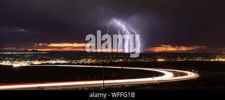 Il cloud e la messa a terra il fulmine colpisce la Valle Superiore di El Paso, Texas, Stati Uniti d'America, nel mese di agosto 2019, con curvatura sentieri di luce da strada Transmountain. Foto Stock