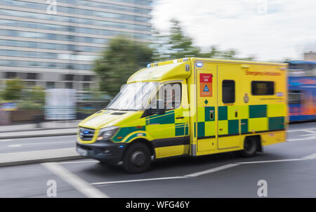 London Ambulance Service NHS ambulanza su una chiamata con luci blu, che mostra il movimento sfocatura da movimento veloce, nel centro di Londra, Inghilterra, Regno Unito. Foto Stock