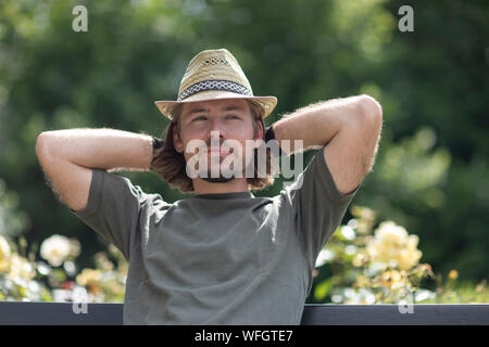 Uomo seduto in giardino nella rilassante tra il giardinaggio, Germania Foto Stock