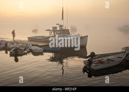 Lobstermen preparare alla testa in acqua durante una mattinata nebbiosa sunrise a cinque delle isole Harbor, Maine. Foto Stock