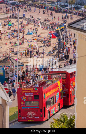 Vista dall'alto di turisti per i turisti e visitatori sulla spiaggia sabbiosa al Victorian seaside resort di Llandudno North Wales con bus aperti Foto Stock