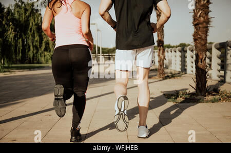 Coppia di uomini caucasici e Latina le donne correre. Ripresa fotografica dal retro Foto Stock