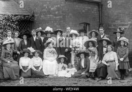 Una vendemmia tardiva o vittoriano inizio Edwardian fotografia in bianco e nero che mostra una festa di nozze in posa per la fotocamera in una impostazione all'aperto. Molto di moda tipica dell'epoca sul display. Foto Stock