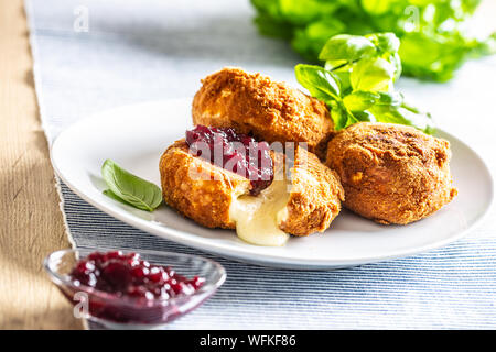 Camembert fritto o formaggio brie con marmellata di mirtilli e basilico Foto Stock