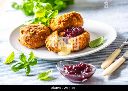 Camembert fritto o formaggio brie con marmellata di mirtilli e basilico Foto Stock