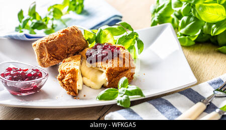 Camembert fritto o formaggio brie con marmellata di mirtilli e basilico Foto Stock