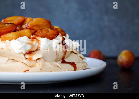 La cannella pavlova con purea di prugne Foto Stock