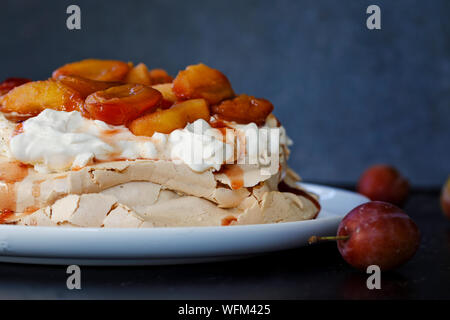 La cannella pavlova con purea di prugne Foto Stock