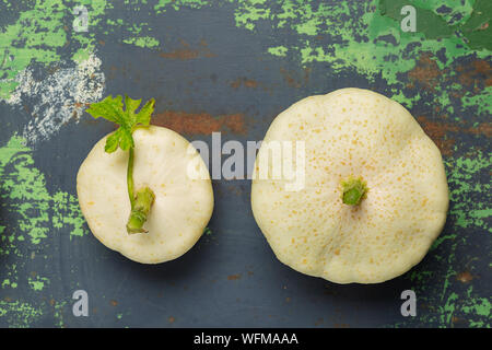 Due bianco fresco squash verdure su ferro vecchio sfondo colorato. Vista da sopra con lo spazio di copia Foto Stock