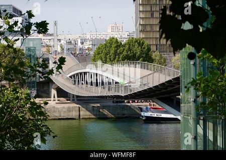 La gente sulla passerella Simone de Beauvoir ponte pedonale attraverso il Fiume Senna, guardando a sud verso la biblioteca di Parigi, Francia. Foto Stock