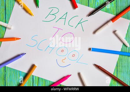Idea creativa che raffigura il ritorno dei bambini a scuola. I marcatori di scuola e di una scheda con il testo torna a scuola. Foto Stock