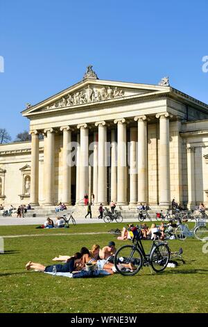 In Germania, in Baviera, Monaco di Baviera, Königsplatz, Glyptothek, museo fondata nel 1830 dal re Luigi I di Baviera per accogliere le sue collezioni di sculture greche e romane, studente lavora appoggiata contro la facciata neoclassica Foto Stock