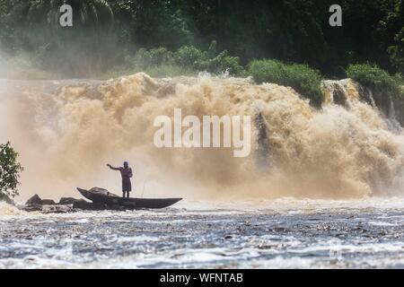 In Camerun, regione sud, Dipartimento dell'oceano, Kribi, pescatore in una canoa nella parte anteriore del lobo cascata Foto Stock