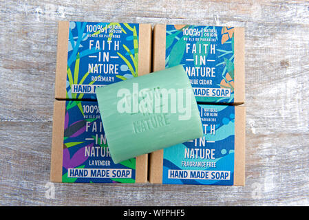 La fede nella natura artigianale vegano etico sapone sostenibile in imballaggi di cartone sul legno naturale dello sfondo. Foto Stock