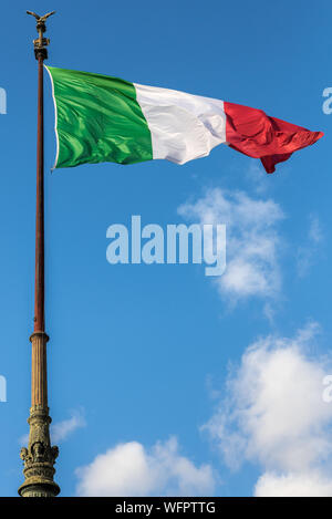 Bandiera Italiana waveing a Roma con il cielo azzurro sullo sfondo Foto Stock