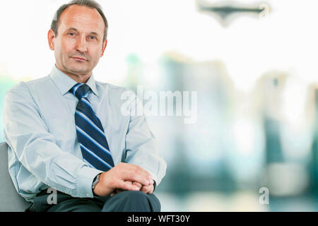 Portrait - avvocato consulente seduto nella mia poltrona scrivania sulla luce sfondo sfocato foto ha uno spazio vuoto per il testo Foto Stock