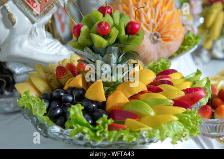 Un trito di frutti in un vaso di vetro.piatto di fette di frutta di stagione come kiwi, ananas, Nervatura, limone, mela pronto a mangiare. Mangiare sano e stile di vita. Freschi Foto Stock