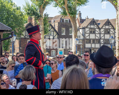 Londra, Inghilterra - 5 Agosto 2018: Un Yeomen Warder all'interno della Torre di Londra in una calda giornata estiva dando un discorso a un gruppo. Questo storico Castello Normanno Foto Stock