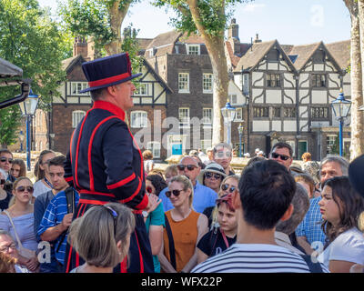 Londra, Inghilterra - 5 Agosto 2018: Un Yeomen Warder all'interno della Torre di Londra in una calda giornata estiva dando un discorso a un gruppo. Questo storico Castello Normanno Foto Stock