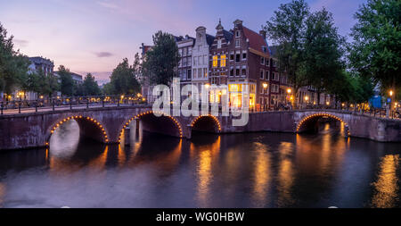 Immagine panoramica del canale Keizersgracht nel cuore di Amsterdam. Vecchie case sono visibili sulla riva opposta del canale. Foto Stock