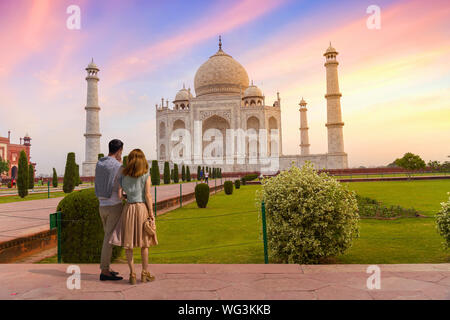 Turista giovane godono di vista del Taj Mahal Agra a sunrise con moody sky Foto Stock