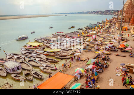 Varanasi Gange fiume ghat vista aerea con architettura antica e barche di legno allineate lungo la riva del fiume Foto Stock