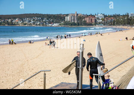 Surfisti a Manly Beach a Sydney lavando le loro tavole da surf sotto la doccia spiaggia,Sydney , Australia Foto Stock