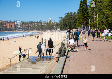 Surfisti a Manly Beach a Sydney lavando le loro tavole da surf sotto la doccia spiaggia,Sydney , Australia Foto Stock