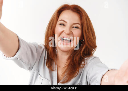 La felicità, l'età, il concetto di famiglia. Allegro buona carismatica-cercando di mezza età redhead madre felice vedere nipoti venite a visitare estendono bracci coccola loo Foto Stock