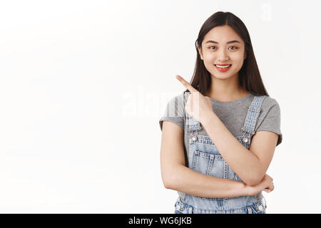 Vita-up amichevole entusiasta carino asian brunette girl spiegare luogo fresco appendere fuori visualizza link utili rivolta verso l'angolo superiore sinistro sorriso consiglia Foto Stock