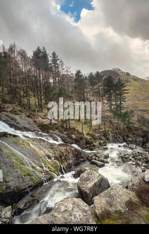 Bella immagine di panorama di Ogwen Valle del fiume e cascate durante il periodo invernale con cime innevate sullo sfondo Foto Stock