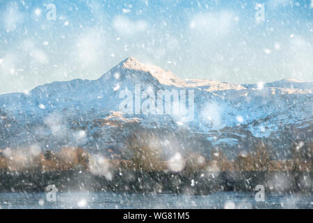 Incantevole paesaggio invernale immagine di Mount Snowdon e altri picchi nel Parco Nazionale di Snowdonia in pesante tempesta di neve Foto Stock