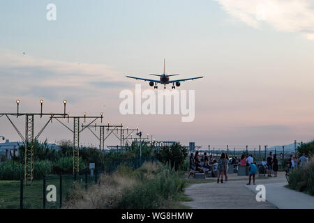 Aerei di atterraggio nell'aeroporto El Prat di Barcellona sorvolo di un gruppo di persone Foto Stock