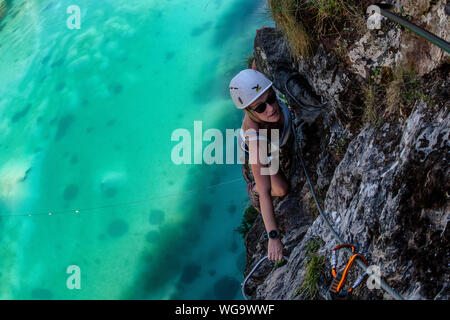 Una donna si sale la via ferrata sopra Lac de la rosière accanto al francese stazione sciistica di Courchevel nelle Alpi durante l'estate. Foto Stock