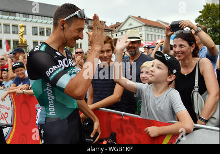 Erfurt, Germania. 01 Sep, 2019. Escursioni in bicicletta: UCI Europaserie - Germania Tour, fase 4, Eisenach - Erfurt (159, 50 km). Il tedesco Marcus BURGHARDT da Team Bora-Hansgrohe tubicini le mani con un giovane fan. Credito: Bernd Thissen/dpa/Alamy Live News Foto Stock