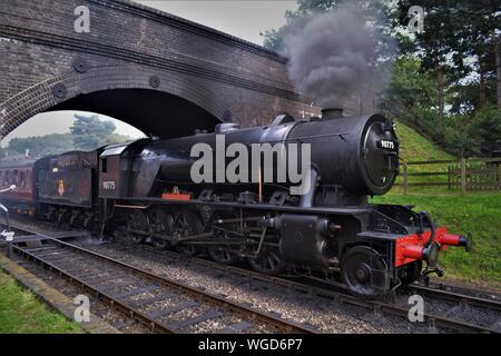 Royal Norfolk reggimento locomotiva a vapore del North Norfolk Railway con il ponte alla stazione weyborne anche per la cottura a vapore Foto Stock