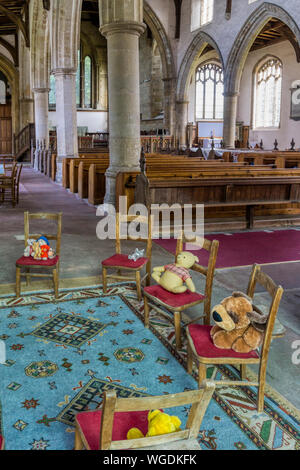 Angolo bambini della chiesa parrocchiale con giocattoli morbidi. Chiesa di tutti i Santi di Thornham, Norfolk. Foto Stock