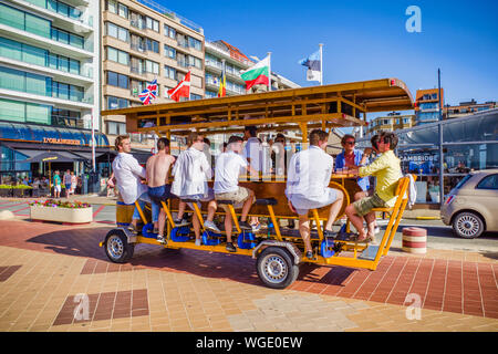 Knokke, Belgio - 29 Giugno 2019: turisti sulla birra bici alla stazione balneare di Knokke-Heist lungo la costa del Mare del Nord, Fiandre Occidentali Foto Stock