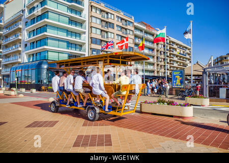 Knokke, Belgio - 29 Giugno 2019: turisti sulla birra bici alla stazione balneare di Knokke-Heist lungo la costa del Mare del Nord, Fiandre Occidentali Foto Stock