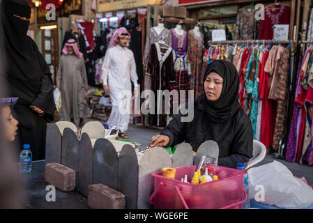 Doha, Qatar - 17 DIC 2016: Un asiatico donna musulmana è la preparazione di crepes nella strada pedonale del Souq Wakif, Doha Foto Stock