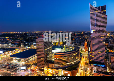 Centro di Varsavia in Polonia, vista in elevazione notte cityscape con edifici di appartamenti, shopping mall e la stazione ferroviaria centrale, Foto Stock