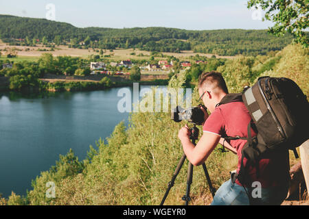 Fotografo di prendere foto di fauna selvatica, uomo con impostazione della fotocamera su un treppiede Foto Stock